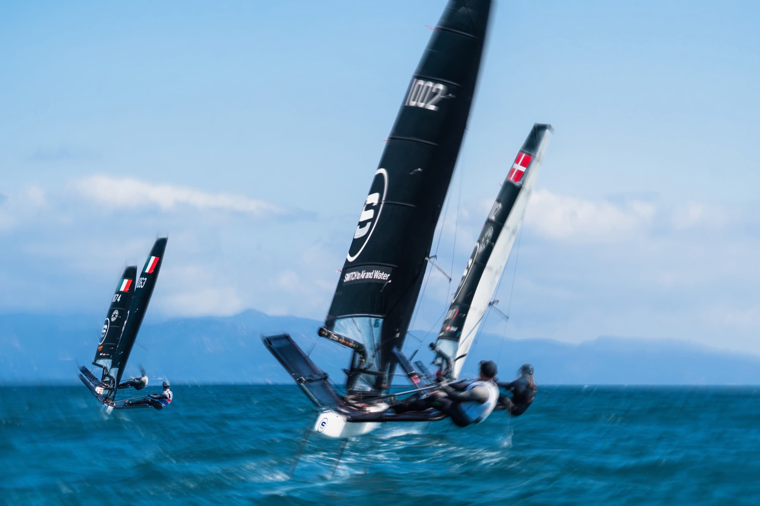 High-performance sailing skiffs racing side by side during a competitive sailing training session.